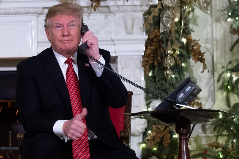 President Donald Trump speaks on the telephone as he answers calls from people calling into the NORAD Santa tracker phone line in the State Dining Room of the White House in Washington, D.C. on December 24, 2018.
